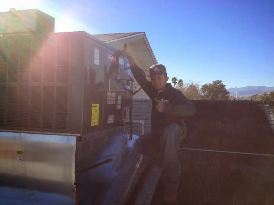 HVAC technician performing HVAC Inspection on a rooftop unit in Francisville